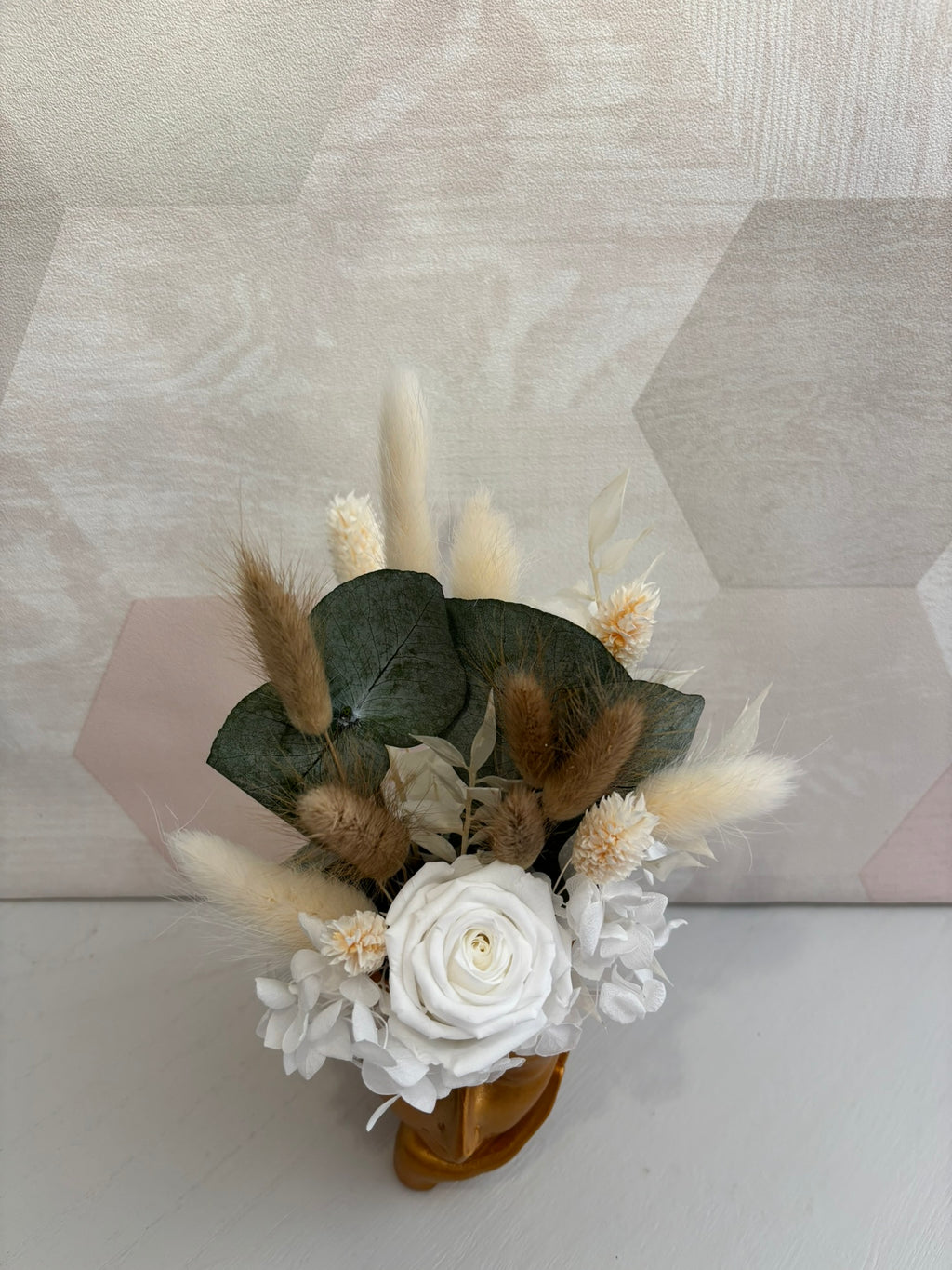 Composition florale avec une fleur d'or orange de la marque Rêves En Fleurs, disposée dans un arrangement élégant.