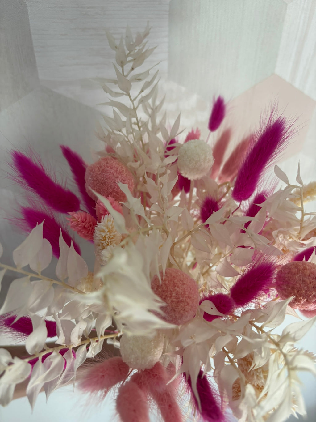Bouquet de fleurs fuchsia Rêves En Fleurs avec des fleurs roses vives et des feuillages verts, présenté dans un arrangement élégant.