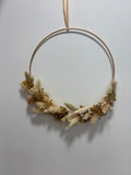 Couronne végétale Éclat de la marque Rêves En Fleurs posée sur une surface naturelle, avec des fleurs colorées et des feuillages.