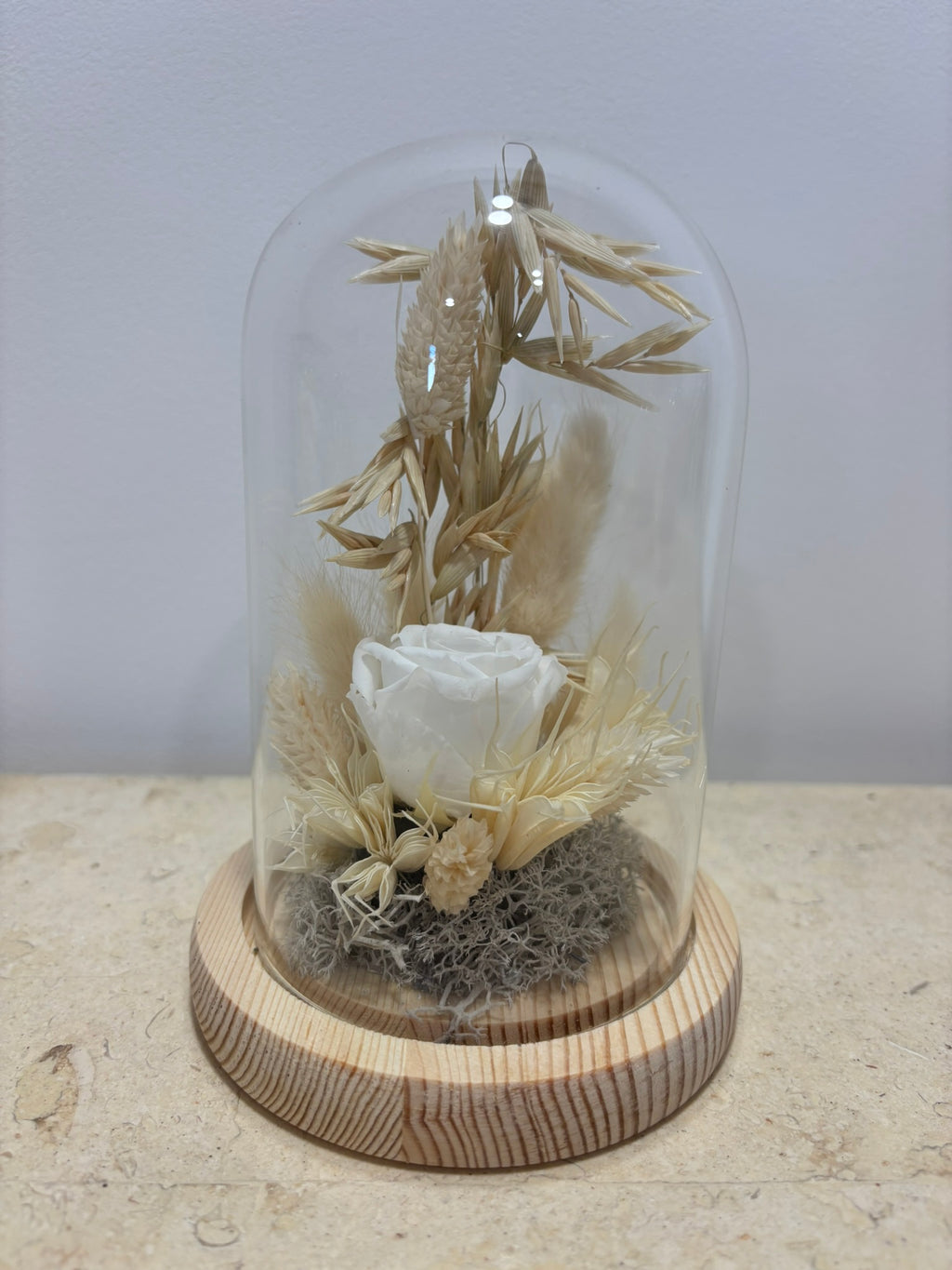 Cloche blanche élégante de la marque Rêves En Fleurs, en verre transparent avec base en bois naturel.