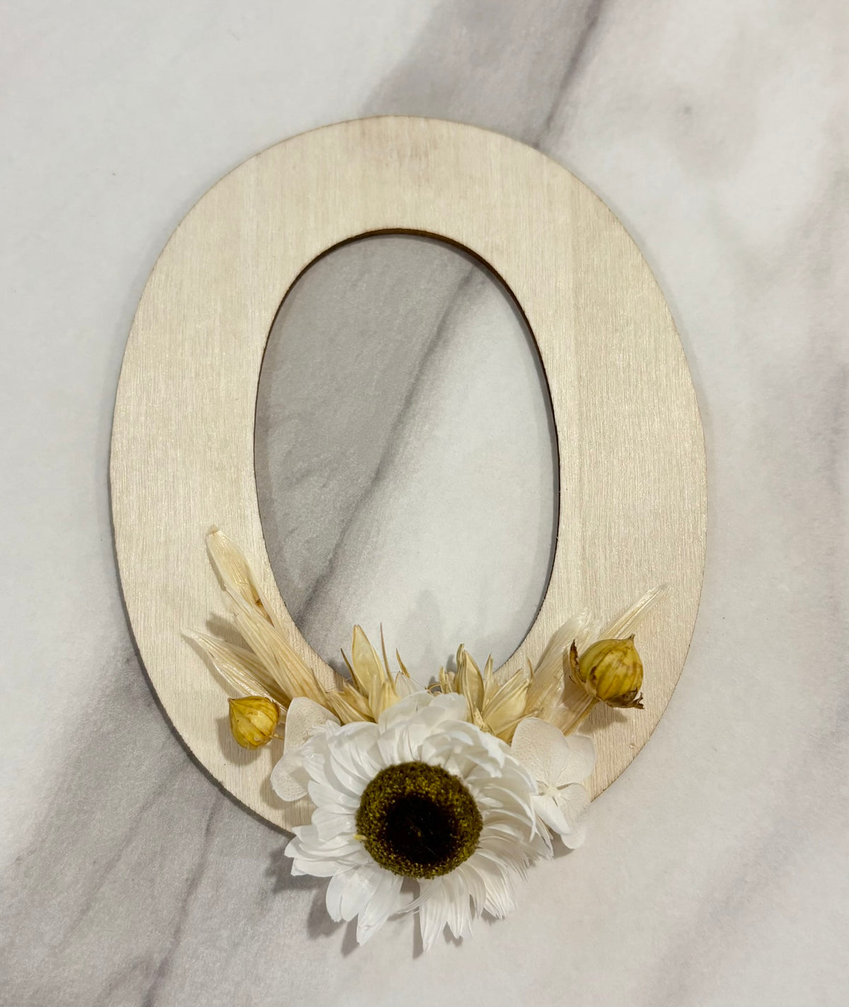 Barrette lettre Rêves En Fleurs en métal doré, décorée de motifs floraux, portée comme accessoire de cheveux élégante.