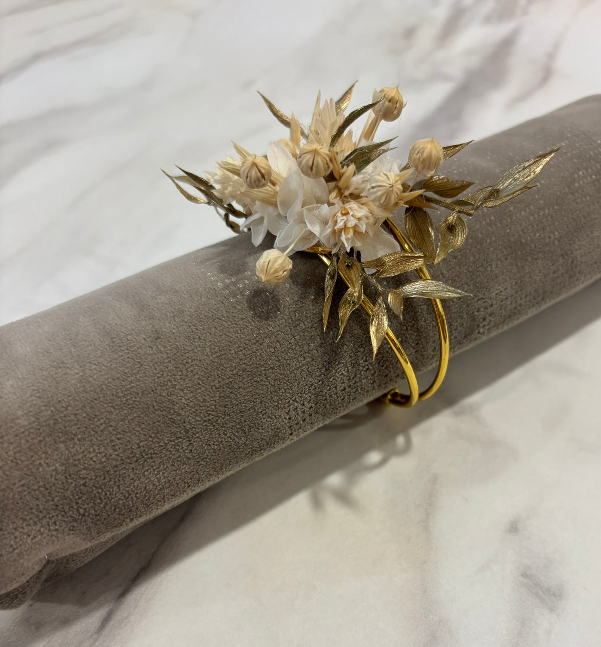 Bracelet blanc et doré Rêves En Fleurs avec pendentif délicat, porté au poignet, élégant et tendance.