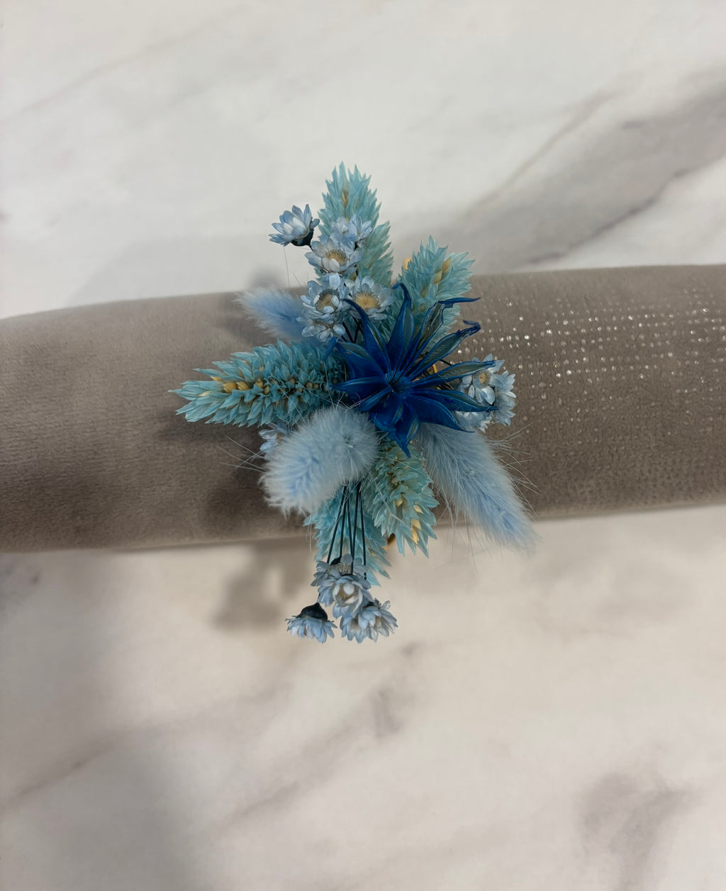 Bracelet bleu en tissu avec perles, fabriqué par Rêves En Fleurs, porté au poignet dans une vue rapprochée.