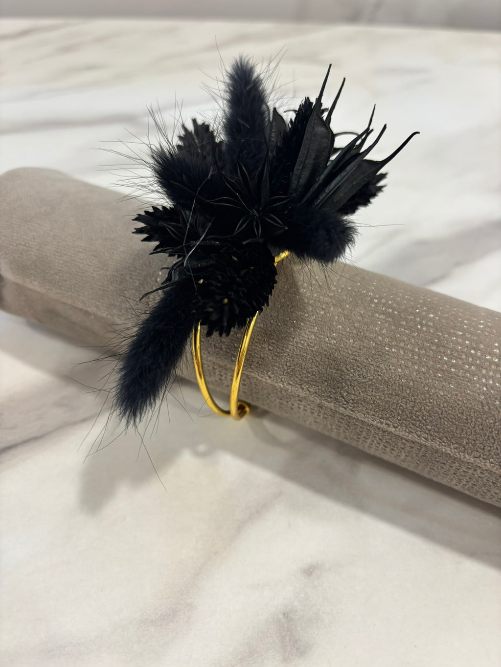 Bracelet noir en cuir de la marque Rêves En Fleurs, avec détails élégants, porté sur le poignet.