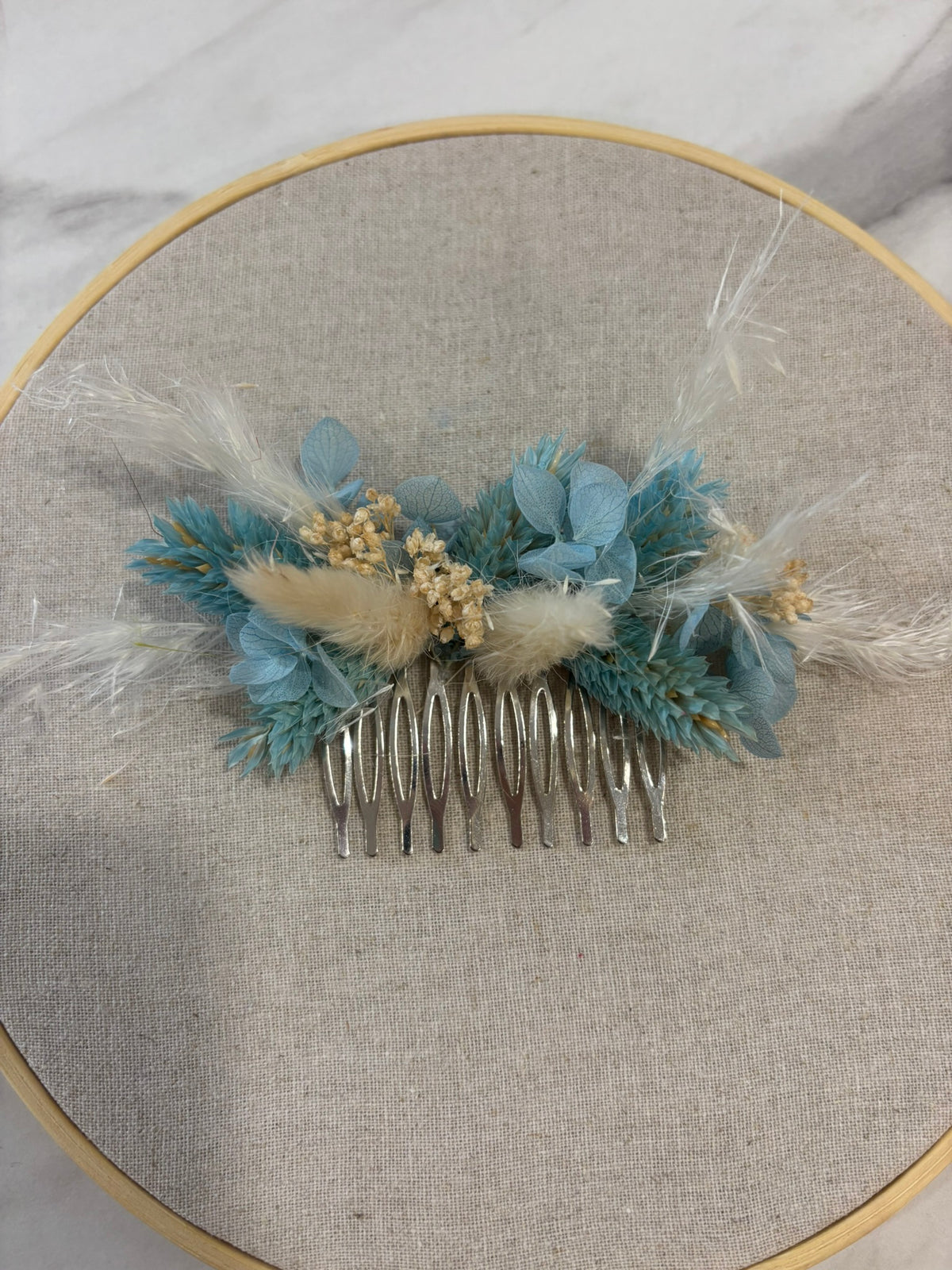 Peigne bleu et blanc de la marque Rêves En Fleurs, en plastique, avec dents fines pour démêler les cheveux.