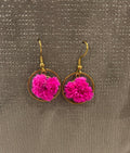 Boucles d'oreilles roses Rêves En Fleurs en métal avec pendentifs floraux, portée élégante et féminine.
