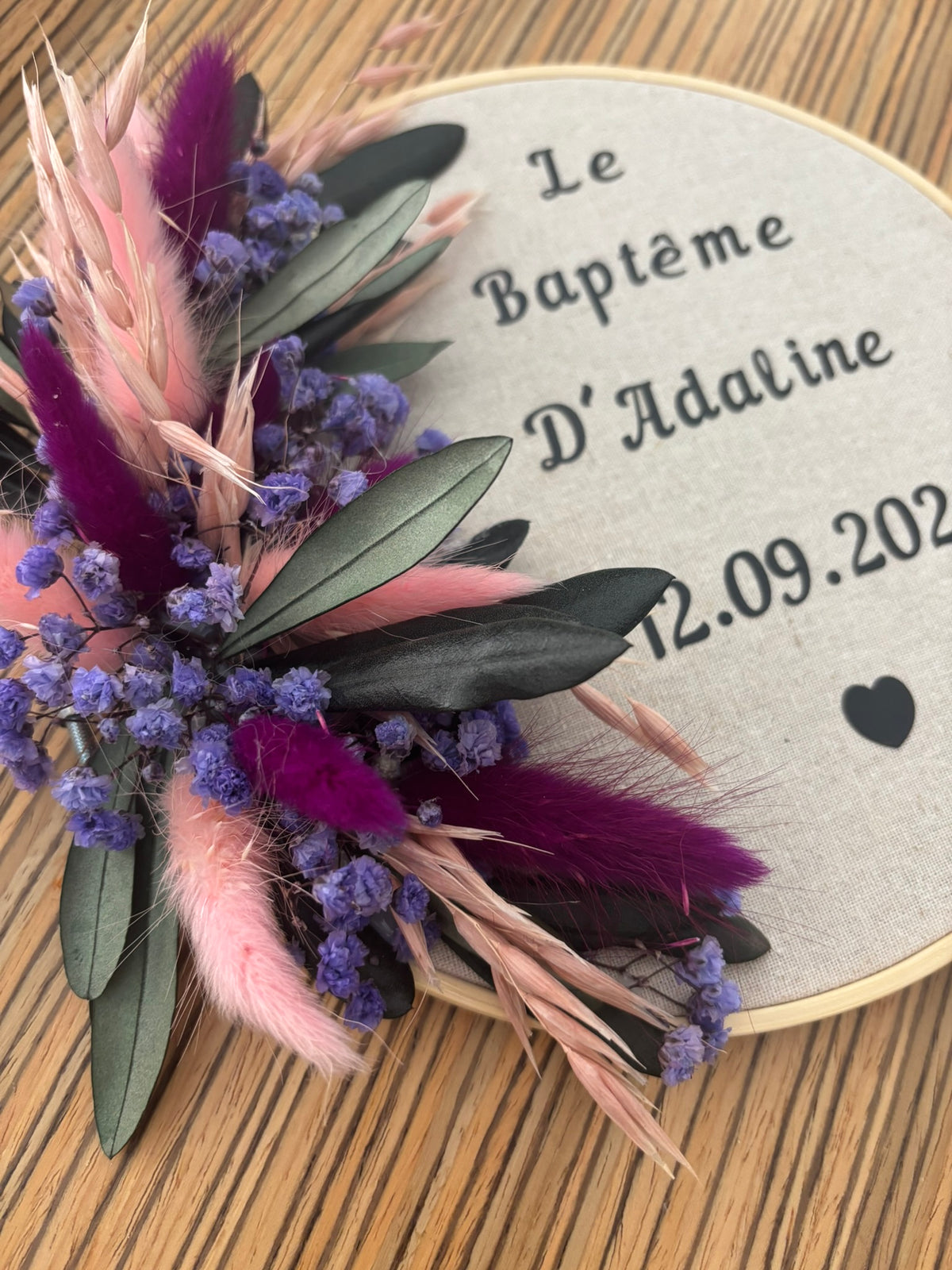 Tambour Rêves En Fleurs avec surface décorative colorée et baguettes en bois sur fond blanc.