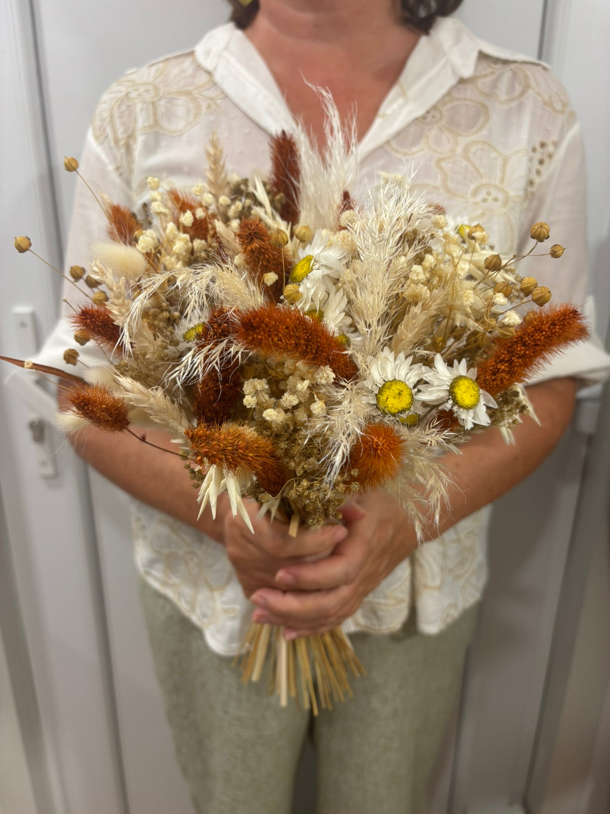 Bouquet de mariée élégant avec des fleurs blanches et vertes, conçu par Rêves En Fleurs, prêt pour un mariage.