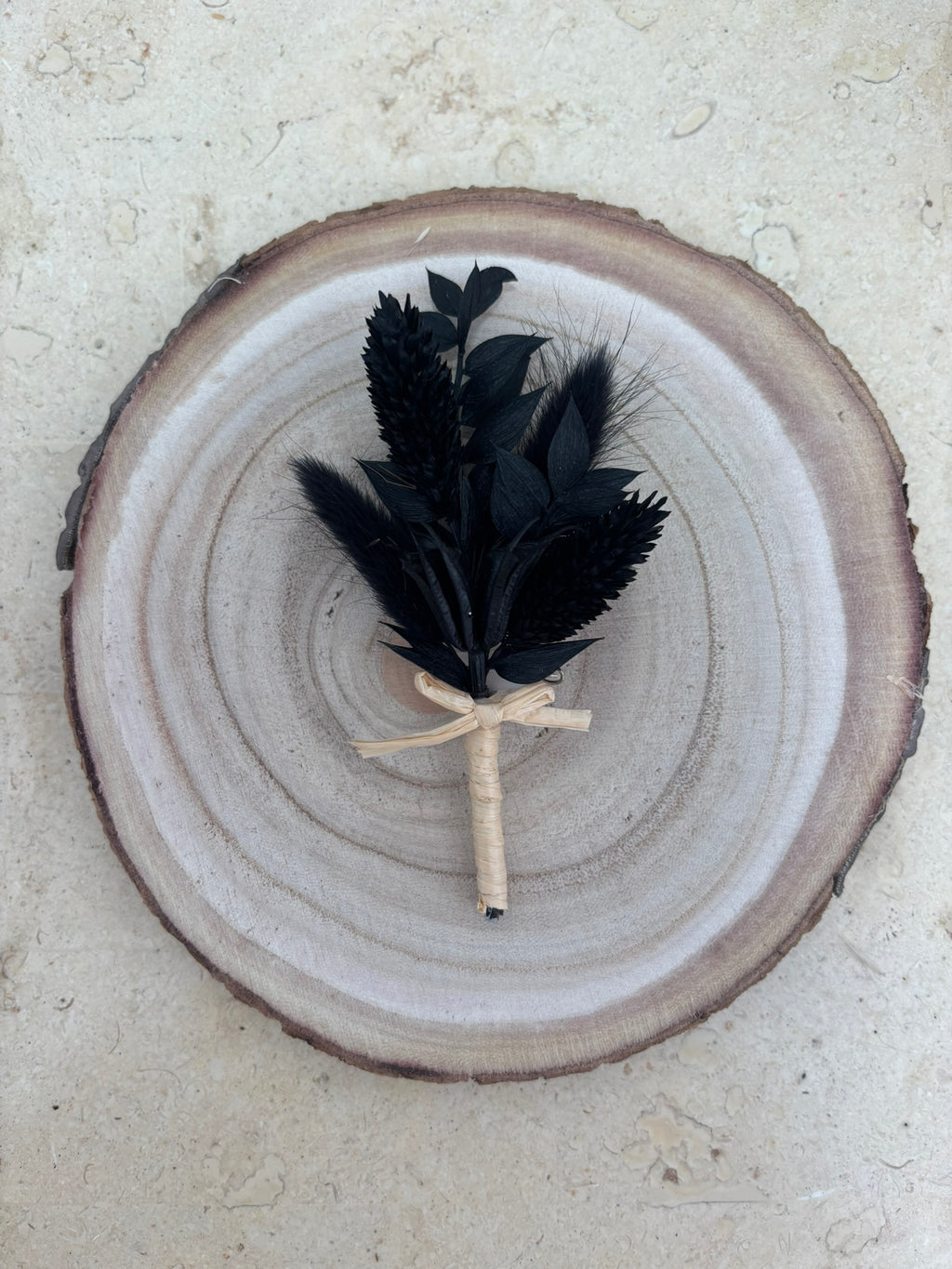 Boutonnière noir de la marque Rêves En Fleurs, boucle d'oreille élégante avec détails floraux noirs.